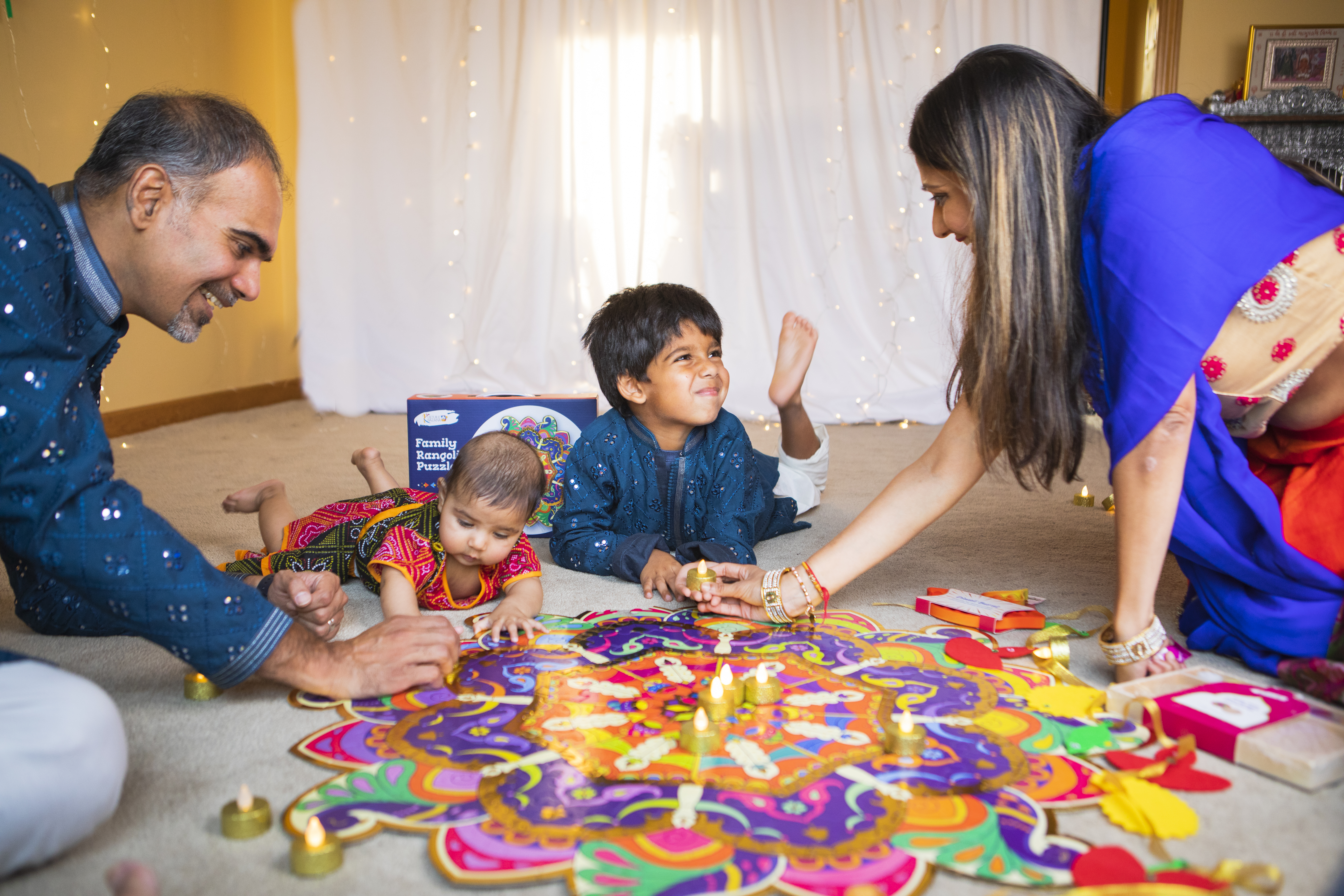 Indian American family celebrating Diwali at home, building a Kulture Khazana Family Rangoli Puzzle surrounded by diyas